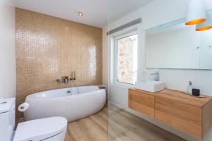 a bathroom with a tub and a toilet and a sink at Casa Marina in Costa Teguise +26 photos