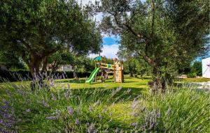 un parco giochi in un parco con alberi e fiori viola di 4 Bedroom Stunning Home In Rakalj a Rakalj Altre 40 foto