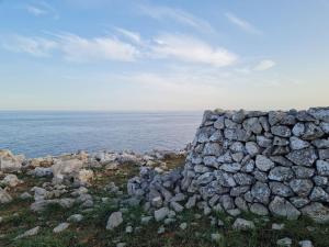 a stone wall on the side of the ocean at Appartamento tra sole, mare e natura in Otranto