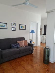 ein Wohnzimmer mit einer Couch auf einem Fliesenboden in der Unterkunft Appartamento tra sole, mare e natura in Otranto