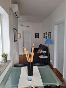 ein Wohnzimmer mit einem Tisch und einer Vase voller Stöcke in der Unterkunft Appartamento tra sole, mare e natura in Otranto + 48 Fotos