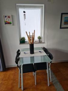 ein Tisch mit Stühlen und einer Vase darauf in der Unterkunft Appartamento tra sole, mare e natura in Otranto