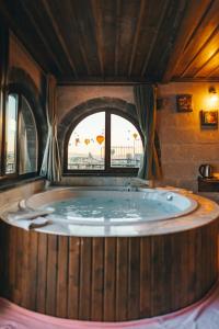 a jacuzzi tub in a room with a window at Goreme Valley Cave House in Göreme