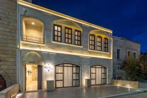 ギョレメにあるMare Cappadociaの夜間の窓とドアが付く大きな白い建物