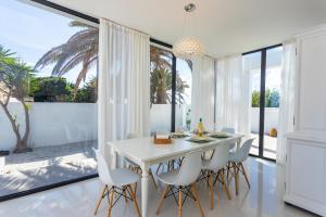 a white dining room with a white table and chairs at Casa Marina in Costa Teguise