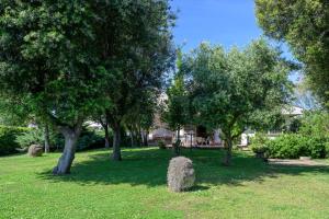 a park with trees and a house in the background at Villa Marisa in Fregene