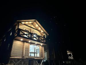 a wooden building with a window at night at SVOI Chalet in Vyshka