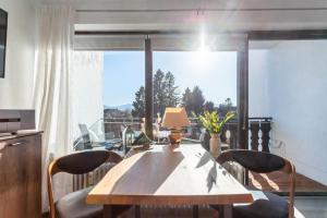 a dining room table with chairs and a large window at Ferienwohnung Seebruck in Seebruck