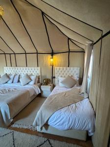 une chambre avec deux lits dans une tente dans l'établissement Salam Luxury Camp, à Merzouga