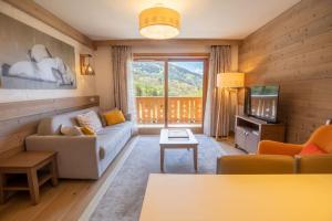 美贝尔MERIBEL Appartement Résidence PREMIUM Hevana的带沙发和电视的客厅