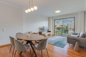 un salon avec une table, des chaises et un canapé dans l'établissement Barreiros Residence I, à Funchal