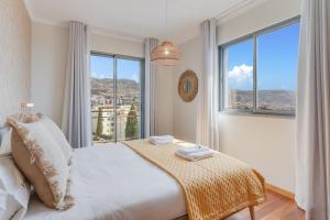 une chambre avec un lit et une grande fenêtre dans l'établissement Barreiros Residence I, à Funchal