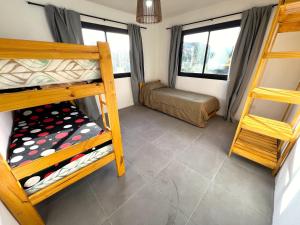 a room with two bunk beds and a couch at Alquiler Mar del Plata Casa en Acantilados in Mar del Plata