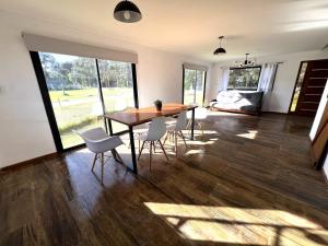 a living room with a wooden table and chairs at Alquiler Mar del Plata Casa en Acantilados in Mar del Plata
