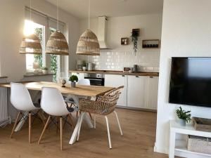 a kitchen with a table and chairs and a television at Weser-City-Panorama 2Zi 9OG 5P Mitte in Bremerhaven
