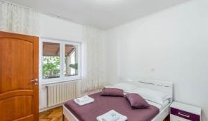 sypialnia z łóżkiem i oknem w obiekcie Apartments Jope w mieście Stara Novalja