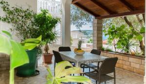 patio ze stołem, krzesłami i roślinami w obiekcie Apartments Jope w mieście Stara Novalja