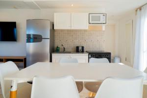 a kitchen with a white table and chairs and a refrigerator at Departamentos NIZA 313 in Ostende +33 photos