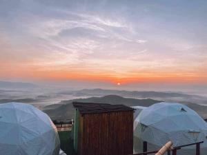 two tents on top of a mountain at sunset at ดอยสะโง้วิวโฮมสเตย์โดมบอล in Chiang Saen