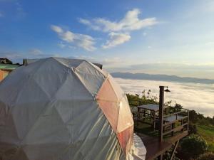 a tent sitting on top of a hill with clouds at ดอยสะโง้วิวโฮมสเตย์โดมบอล in Chiang Saen