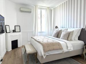 een witte slaapkamer met een bed en een open haard bij A 2 pas de la croisette in Cannes