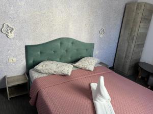 a bedroom with a bed with a green headboard at Hotel AmA in Constanţa