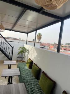 einen Balkon mit einem grünen Sofa und einem Tisch in der Unterkunft Habibi Riad&Hostel in Marrakesch