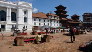 a group of people sitting on a brick street at Kathmandu home in Kathmandu