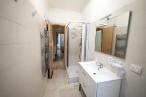 a white bathroom with a sink and a mirror at Home Joséphine - CASERTA in Caserta +38 photos