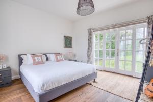 a white bedroom with a bed and a window at Beautiful Country House with Forest View & Garden in Norleywood