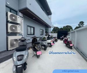 eine Reihe von Motorrollern, die außerhalb eines Gebäudes geparkt sind in der Unterkunft Carina PoolVilla Khanom คารีน่าพูลวิลล่า in Ban Phang Phrao