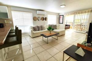 a living room with a couch and a table at 1 Anchor Bay in Cape Town