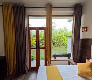 Chabee N Jay Villa Madiha Beach في ماتارا: غرفة نوم بها سرير ونافذة كبيرة