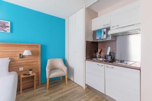 a small kitchen with a table and a chair in a room at Appart’City Confort Vannes in Vannes