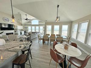 a living room with tables and chairs and windows at SN8023 - Pier Bliss in Whalebone