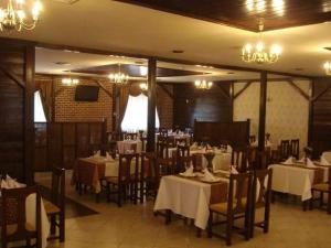 een eetkamer met tafels en stoelen en kroonluchters bij La Salcii in Călăraşi