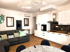 a living room with a couch and a kitchen at Appartamento "Laghetto 1" con tre camere e bagni privati cucina in condivisione in Castel San Pietro Terme