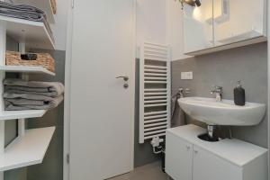 a white bathroom with a sink and a mirror at Citycenter Living 1Zi HP 2P Mitte in Bremerhaven