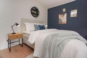 a bedroom with a bed and a table with a lamp at Citycenter Living 1Zi HP 2P Mitte in Bremerhaven