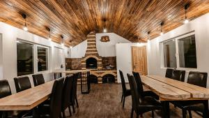 a dining room with wooden tables and chairs and a fireplace at Moldav-A Frame in Câmpulung Moldovenesc