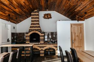 a kitchen with a brick fireplace and a table and chairs at Moldav-A Frame in Câmpulung Moldovenesc