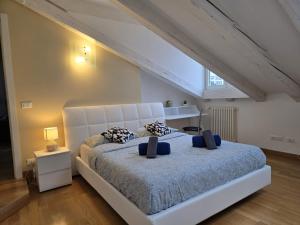 Un dormitorio con una gran cama blanca con almohadas azules. en Mohho suite, en Trieste