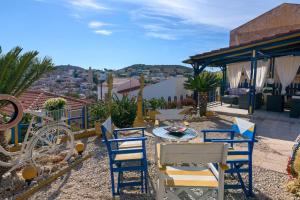 a patio with chairs and a table on a roof at Yellow Oasis traditional home with sea view in Halki +25 photos