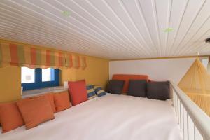a room with orange and black pillows and a ceiling at Yellow Oasis traditional home with sea view in Halki