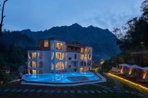 张家界Zhangjiajie Juanjie Luxury Resorts--Provide free one-way airport pick-up service的一座前面有游泳池的建筑