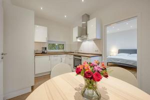 a kitchen with a vase of flowers on a table at Ruhiges Haus nahe Arena & Stadion mit Parkmöglichkeiten - AC Hanse Hosting in Hamburg