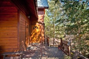 a wooden walkway leading to the side of a cabin at Domek z kominkiem w Krynicy in Krynica Zdrój