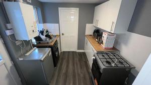 a small kitchen with a stove and a sink at Gloucester Haven Retreat in Gloucester
