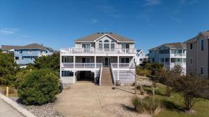 a large white house with a porch at Time to UnWine in Corolla