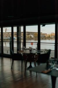 a room with a table and chairs and a view of a river at Radisson Blu Hotel Bordeaux in Bordeaux